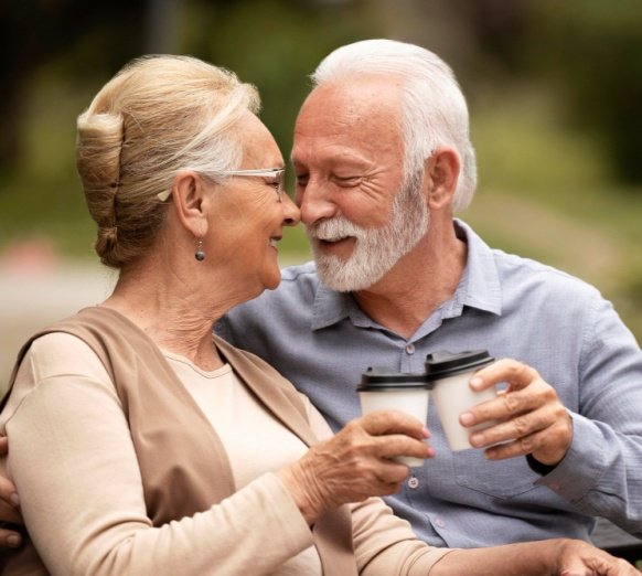 A mature couple smiling together over coffee